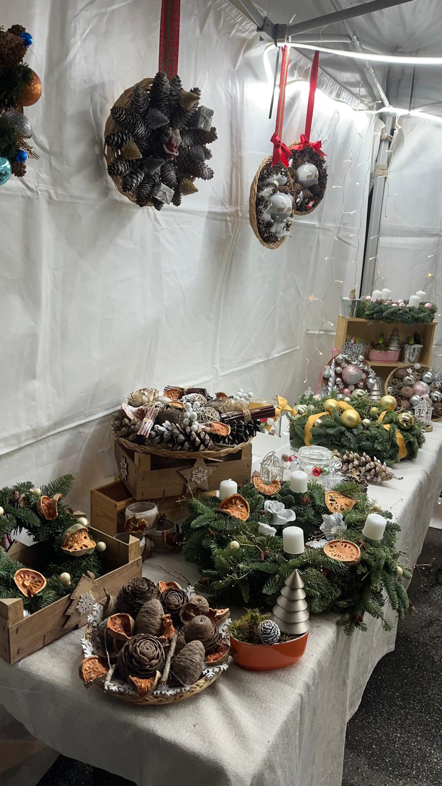 Présentation d'une table sur un marché de noël avec des créations de couronnes en fleurs séchées et fraîches à Vélizy-Villacoublay 78